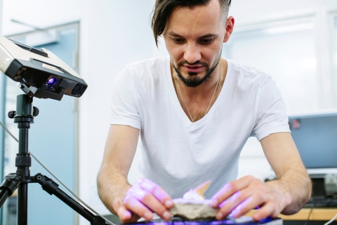 Student holds rock in the metrology lab