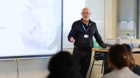 A student presenting his research in a lecture theatre