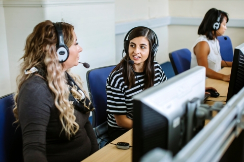two female students speaking with headsets