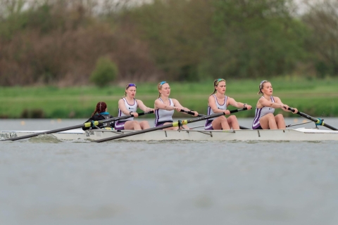 Crew of four women rowing on a river 