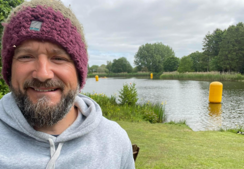 Study participant Richard Williams smiling at the camera in front of a lake