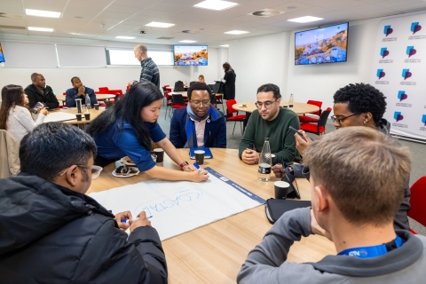 Postgraduate research students collaborating on ideas and writing notes