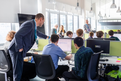 Students receiving IT support from a lecturer