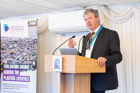 A conference with a male speaking into the microphone