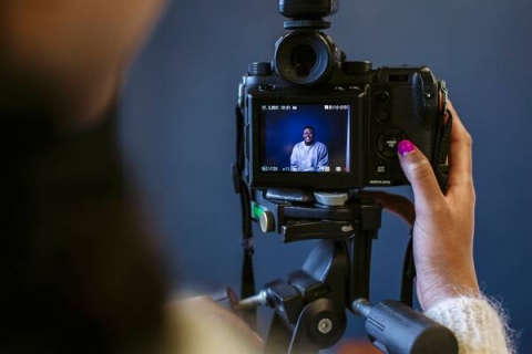 A hand holding a camera with viewfinder on