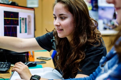 Female engineering student pointing to computer