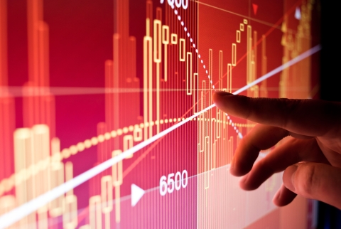A hand gesturing to data on a screen