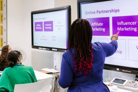 A woman using large screen displays in the TEAL room