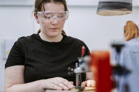 Student cutting objects in the product lab