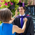 Woman adjusting mans graduation cap