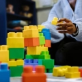 Person building a tower with plastic blocks 