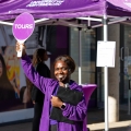 A student holds a purple sign that says "tours."