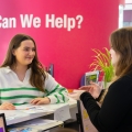 Student standing at front desk talking to a careers advisor 