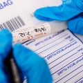 Forensic information technology student labelling an evidence bag wearing gloves
