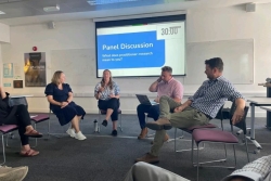 A group of people seated in chairs, attentively watching a presentation on a large screen in front of them.