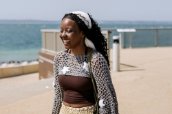 International student Koke walking along seafront smiling