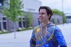 Student wearing colorful hoodie and smiling.