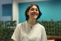 Student wearing white t-shirt and smiling.