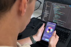 Over the shoulder of a male student opening the Reverie app with a screen showing "How are you feeling?"