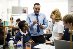 Man teaching four school children