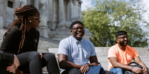 Students smiling on the stairs outside Portsmouth Guildhall