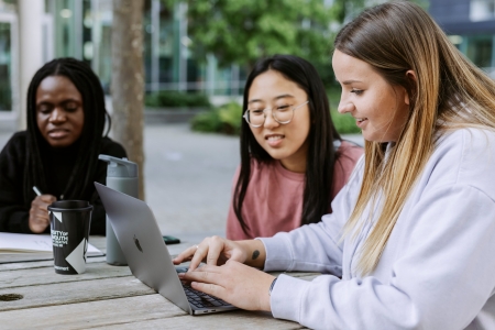 Three students studying on Laptop in Eldon centre outdoor space