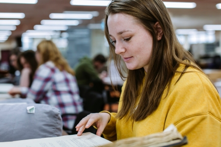 Hannah Coombs researching in the library