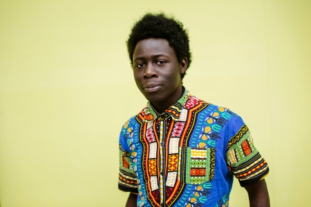 Headshot of postgraduate stood in front of yellow wall