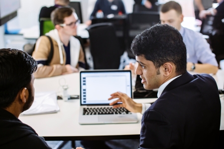 Man working with a colleague at a laptop