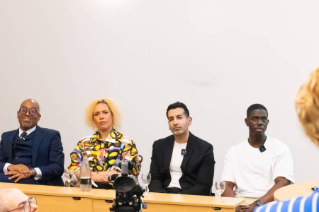 A student asking the panel of speakers a question
