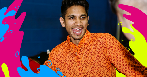 Male student smiling wearing an orange shirt 